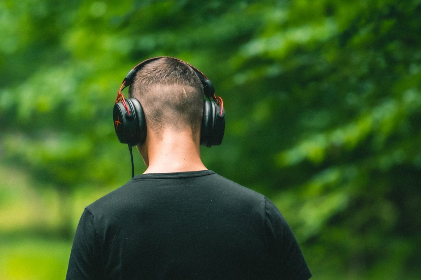 Learner listening with headphones outdoors